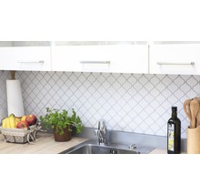 Küchenszene mit Spüle, Armatur, Fliesen und Küchenutensilien