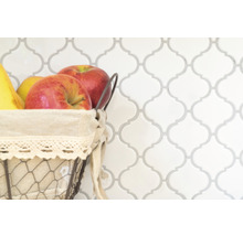 Dekorative Fliesenwand mit Obstkorb im Vordergrund.