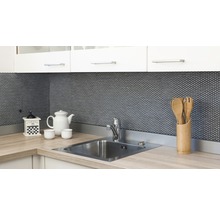 Küchenszene mit Spüle, Armatur, Kaffeemühle, Geschirr und Küchenutensilien vor Mosaikhintergrund