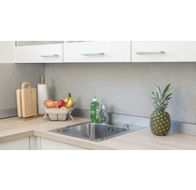 Küchenszene mit Spüle, Armatur, Schneidebrettern, Küchenrolle, Obstkorb und Ananas