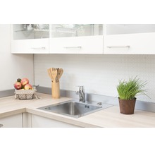 Küchenspüle mit Armatur und Utensilien auf einer hellen Arbeitsplatte