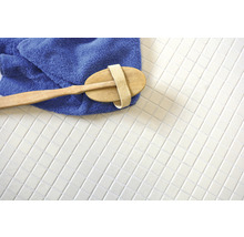 Eine Bürste, ein Handtuch und Fliesen auf einer Oberfläche.