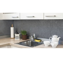 Küchenszene mit Spüle, Armatur, Mosaikfliesen und Küchenutensilien auf der Arbeitsfläche.