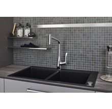 Spüle mit Wasserhahn vor Mosaikfliesenwand