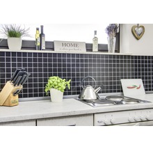 Küchenszene mit Fliesenspiegel, Kochfeld, Wasserkocher und diversen Küchenutensilien