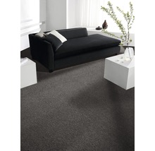 Wohnzimmer mit grauer Auslegeware, schwarzem Sofa und weißen Tischen