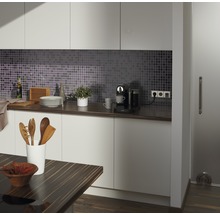 Moderne Küche mit Mosaikfliesen, Arbeitsplatte, Küchenutensilien und Kaffeemaschine.