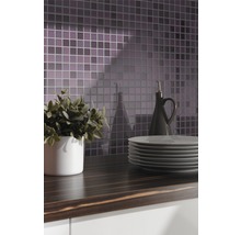 Küchenszene mit Mosaikfliesen, Arbeitsplatte, Geschirr, Pflanze und Ölflasche