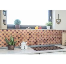 Küchenszene mit Mosaikfliesenwand, Pflanzen und Küchenutensilien auf der Arbeitsplatte.