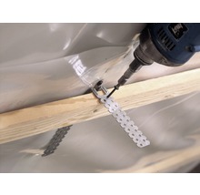 Befestigung einer Dampfbremsfolie mit einem Bohrwerkzeug und einem Lochband an einer Holzlatte.