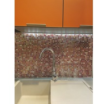 Küchenspüle mit Armatur vor Mosaikfliesen und Hängeschränken