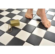 Badezimmerboden mit Schachbrettmuster, Olivenölseife und Füße