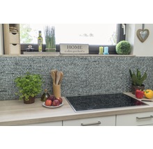 Küchenszene mit Mosaikfliesenwand, Kochfeld und Küchenutensilien auf einer Arbeitsplatte.