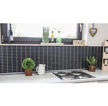 Küchenszene mit schwarzen Fliesen, Kochfeld, Fenstern und Dekorationen.