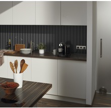 Helle Küche mit dunkler Arbeitsplatte, dunklem Fliesenspiegel und Holzakzenten.