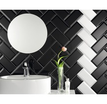 Badezimmer mit Waschbecken, Spiegel und schwarz-weißen Ziegeln im Fischgrätenmuster