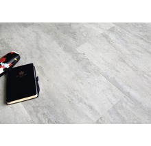 Graue Bodenfliesen mit Notizbuch und Brillenetui