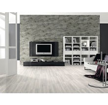 Wohnzimmer mit gemusterter Steinwand, Fernseher, Bücherregal und hellem Holzboden