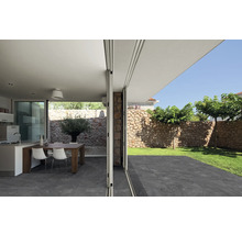 Blick durch eine geöffnete Schiebetür auf Terrasse, Garten und Wohnbereich