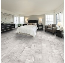 Schlafzimmer mit hellem Bodenbelag in Holzoptik, Bett und Kommode