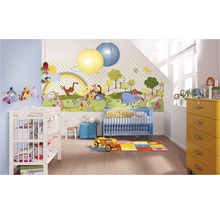 Ein Kinderzimmer mit einer Winnie Puuh Tapete, einem blauen Kinderbett, einer Wickelkommode und einer gelben Kommode.