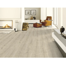 Heller Wohnraum mit Kamin, Sessel und Laminatboden