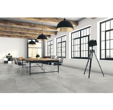 Heller Raum mit Betoneffekt Fliesen, Holzbalken und Büromöbeln.