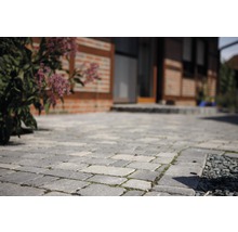 Gepflasterte Auffahrt mit Haus im Hintergrund.