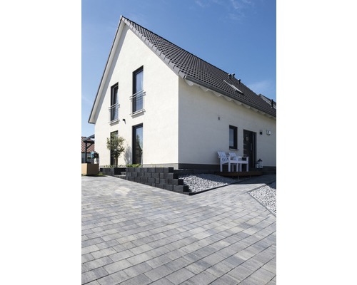 Außenansicht eines Wohnhauses mit Pflastersteinen, Treppenstufen und Terrasse
