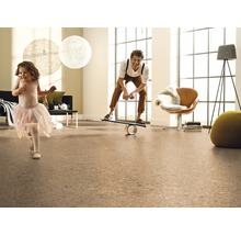 Wohnzimmer mit Korkboden, spielendem Mädchen und Mann auf Balancierbrett