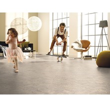 Helles Wohnzimmer mit Bodenbelag, in dem ein Mann auf einem Balance Board steht und ein Kind herumläuft