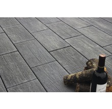 Pflastersteine in Holzoptik mit Weinflasche und Holzscheiten