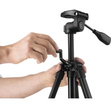 Bedienung eines schwarzen Kamerastativs mit Stativkopf durch Hände