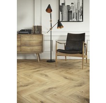 Wohnzimmer mit Fischgrätparkettboden, Sessel und Kommode