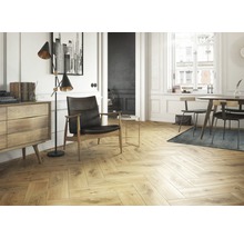 Heller Wohnraum mit Fischgrätenparkett, Sessel und Kommode