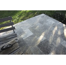 Terrasse mit Travertin Pflastersteinen und Holzbank