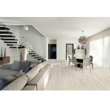 Heller Wohnraum mit Treppe, Sitzgruppe und Essbereich auf Fliesenboden