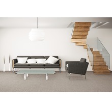Wohnzimmer mit Sofa, Sessel, Tisch, Lampe und Holztreppe