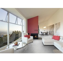 Wohnzimmer mit großem Fenster, Sessel, Sofa, Teppich und Kamin.