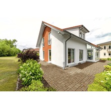 Einfamilienhaus mit gepflasterter Terrasse und Gartenanlage