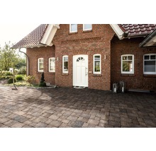 Außenaufnahme eines Wohnhauses mit Pflastersteinen auf dem Vorplatz.