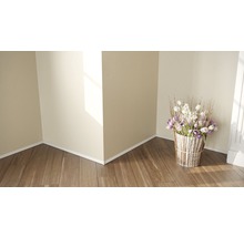 Helle Ecke mit Holzboden, Zierleisten und Blumenarrangement in dekorativem Behälter