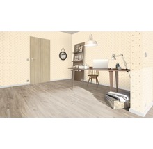 Büro mit Schreibtisch, Stuhl, Regal und Tür in einem Raum mit gemusterter Tapete.