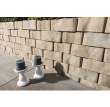 Eine Mauer aus Mauersteinen und zwei Kerzenständer mit Kerzen