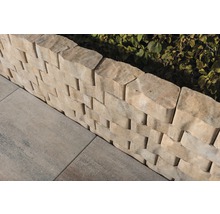 Detailansicht einer Trockenmauer aus Betonsteinen mit Pflastersteinen im Garten