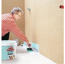 Eine Person trägt Dichtschlämme mit einer Kelle auf, abgedichtet mit Dichtband, Eimer im Vordergrund.