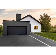 Modernes Einfamilienhaus mit Garage und gepflasterter Auffahrt.