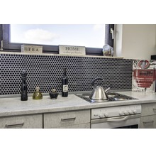 Küchenszene mit Spüle, Herd, Armaturen und Küchenutensilien vor schwarzem Mosaikhintergrund