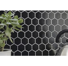 Sechseckige, glänzende, schwarze Fliesen mit weißen Fugen als Hintergrund.