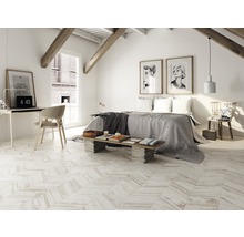 Heller Dachbodenraum mit Holzbalken, Dachfenster, Bett, Schreibtisch und Holzboden im Fischgrätenmuster